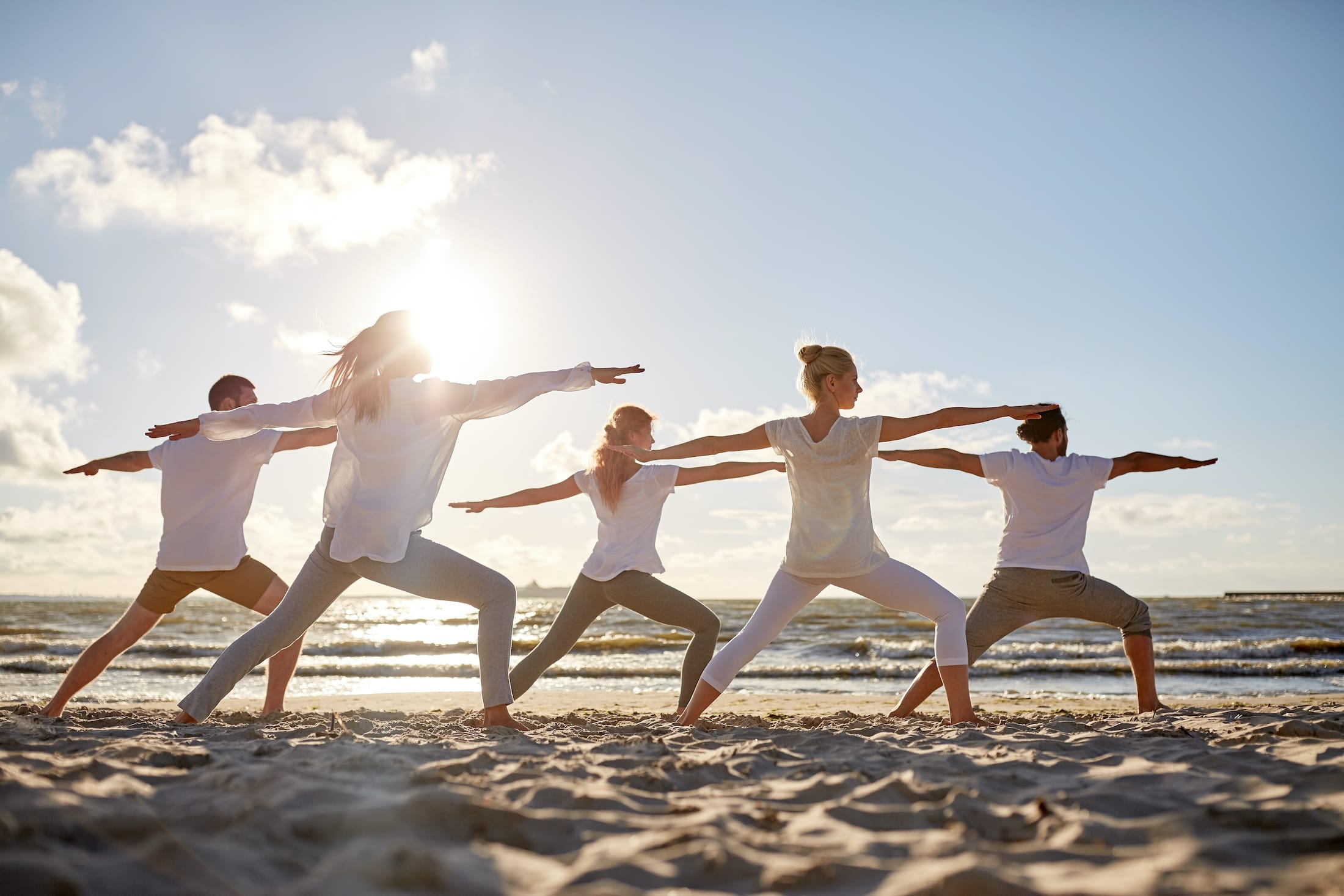 people doing yoga on the beach