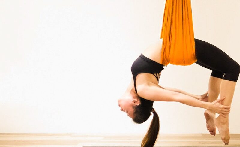 girls doing aerial yoga antigravity in orange silk