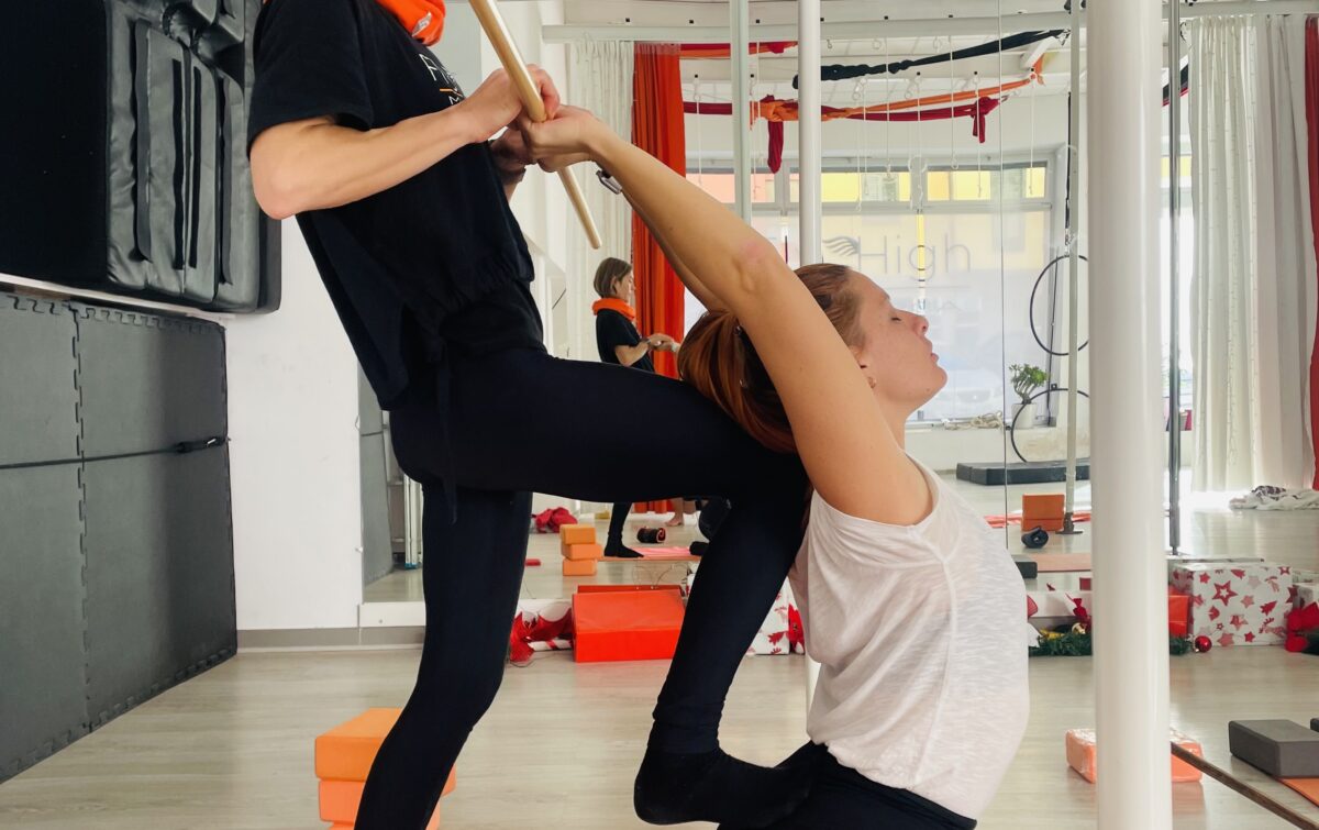 Teacher yoga help girl to improve flexibility of back