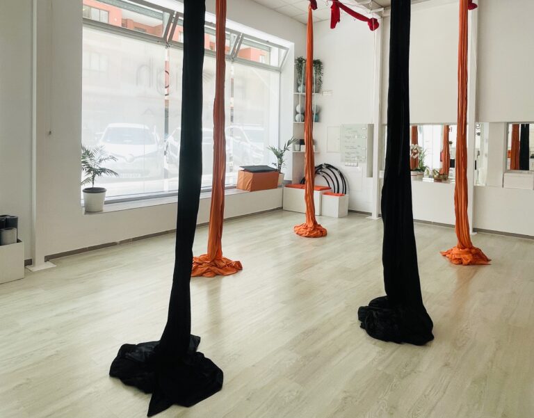 aerial silk studio with white light and black and orange silk
